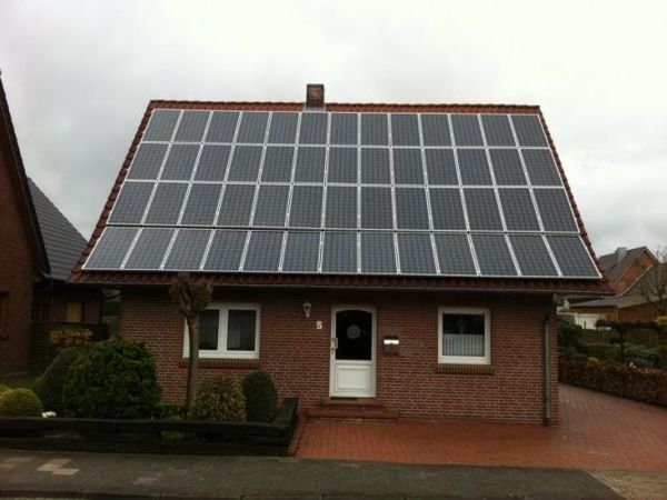 Einfamilienhaus mit großer Photovoltaikanlage auf dem Dach für Solarenergiegewinnung.